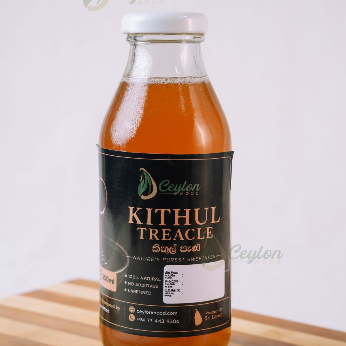Bottle of Pure Kithul Treacle on a wooden board