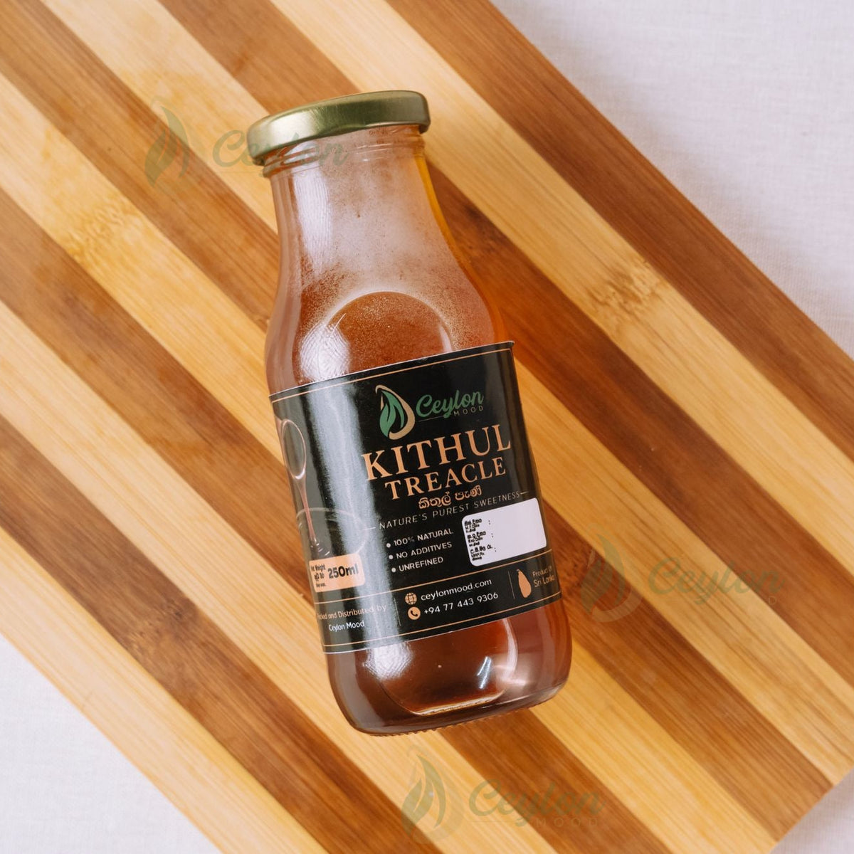 Small bottle of Pure Kithul Treacle lying on a wooden board